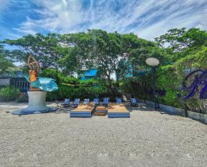 a group of chairs and a statue in a park at Beach Walk Boutique Resort in Bangsaen