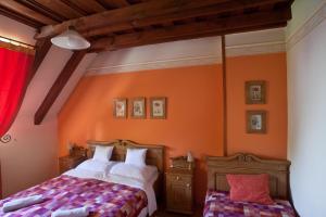 Schlafzimmer mit orangefarbenen Wänden, einem Bett und einem Fenster in der Unterkunft St.Michael Panzió Lovaspark in Vasszentmihály