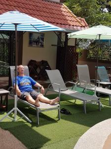 孔敬的住宿－麥泰旅館，坐在一把伞下椅子上的男人