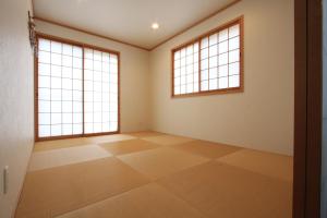 ein leeres Zimmer mit zwei Fenstern und Fliesenboden in der Unterkunft るり渓清流台Z-5-6号棟 in Habu