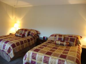 Una cama o camas en una habitación de Helmcken Falls Lodge Cabin Rooms and RV Park