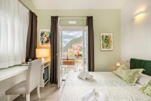 a bedroom with a bed and a desk and a window at Casa Catò in Vernazza