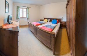 a bedroom with a large wooden bed with a desk at Mosthäusl in Wernstein am Inn