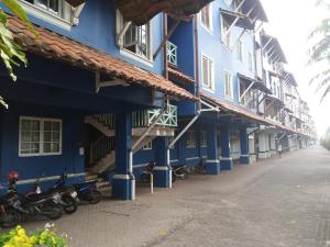 una fila de edificios azules con motocicletas estacionadas fuera en KONDOMINIUM PANTAI CARITA - Neli, en Carita