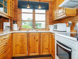 エーベルトフトにある6 person holiday home in Ebeltoftのキッチン(木製キャビネット、白い電化製品付)