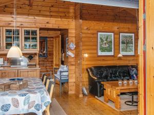 エーベルトフトにある6 person holiday home in Ebeltoftのリビングルーム(テーブル、革張りのソファ付)