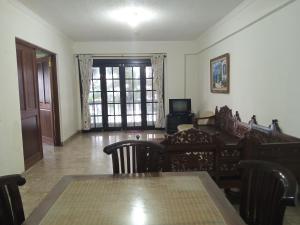 sala de estar con mesa, sillas y ventana en KONDOMINIUM PANTAI CARITA - Neli, en Carita