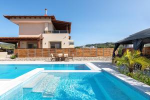 a villa with a swimming pool and a house at Panthea Luxury Villa in Ialysos