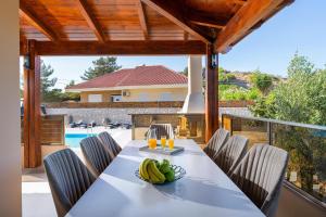 una sala da pranzo con tavolo e sedie su un patio di Panthea Luxury Villa a Trianta