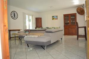 ein Wohnzimmer mit einem Sofa und einem Tisch in der Unterkunft Location saisonnière Les Hirondelles - Manapany in Saint-Joseph