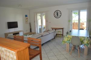 ein Wohnzimmer mit einem Sofa und einem Tisch in der Unterkunft Location saisonnière Les Hirondelles - Manapany in Saint-Joseph