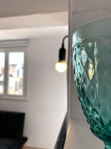 a green glass vase sitting on a table with a light at Katsikantaris Homes in Paphos