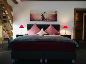 ein Schlafzimmer mit einem großen Bett mit rosa Kissen in der Unterkunft Ferienscheune Maria in Lichtenfels