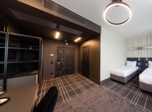 Pokój z 2 łóżkami i biurkiem oraz pokój z łóżkiem w obiekcie Бутик-отель Status w Brześciu