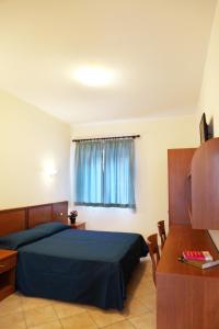 a bedroom with a bed and a desk and a window at Residence Hotel Gloria in Palermo