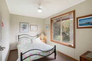 sypialnia z łóżkiem i oknem w obiekcie Monaro Cottage w mieście Eden
