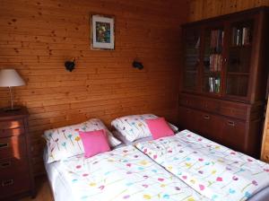 Schlafzimmer mit einem Bett mit rosa und weißen Kissen in der Unterkunft CHALUPA OSTRAVICE in Ostravice