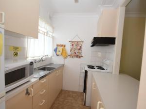 a kitchen with a sink and a microwave at Beachfront 4 Unit 4 of 12 Bundella Ave LC in Lake Cathie