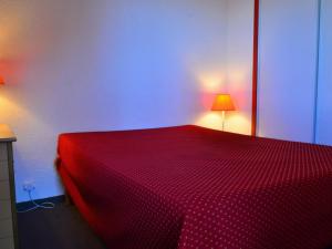 ベラントルにあるAppartement Bellentre, 3 pièces, 6 personnes - FR-1-329-8のランプ2つ付きの部屋の赤いベッド1台