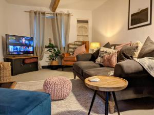 a living room with a couch and a tv at Fern Cottage, Great Strickland in Penrith