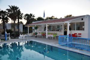 a swimming pool in front of a house at 1-Bedroom Kos Olympia Apartment at Lambi Beach in Kos Town