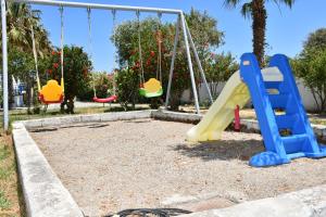 a playground with a slide and swings at 1-Bedroom Kos Olympia Apartment at Lambi Beach in Kos Town