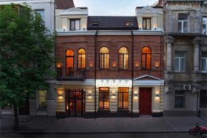 a brick building with many windows on a street at Sherwood Hotel in Rostov on Don