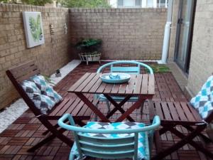 a patio with a wooden table and two chairs at Sundowner Apartment 5 in The Entrance