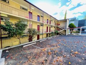 une cour vide d'un bâtiment avec des feuilles au sol dans l'établissement Parklane Motel, à Launceston