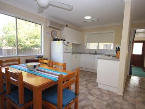 a kitchen with a table and chairs and a refrigerator at North Haven Sea Breeze in North Haven
