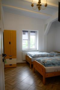 two beds in a room with two windows at Apartament w Karkonoszach Stary Młyn in Kowary