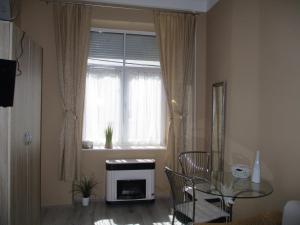 - un salon avec une table en verre et une fenêtre dans l'établissement Ferencesek apartman, à Pécs