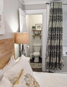 a bedroom with a bed and a bathroom with a toilet at Bramblebank Cottages in Harrison Hot Springs +89 photos