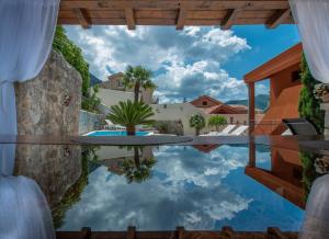 a pool with a reflection of the sky in the water at Apartments Nikčević in Kotor