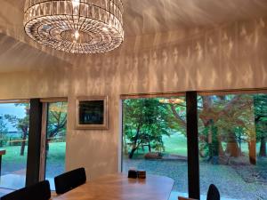 a dining room with a table and a chandelier at La Cachette in Hakodate