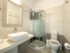 a bathroom with a sink and a shower and a toilet at Eleftheria Hotel & Apartments in Ornos
