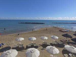 a beach with umbrellas and chairs and the ocean at Hotel Diamante in Francavilla al Mare