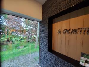 una ventana en una habitación con una pared de ladrillo en La Cachette, en Hakodate