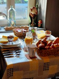 a table with a table cloth with bread and orange juice at Gouarec Bed & Breakfast in Gouarec