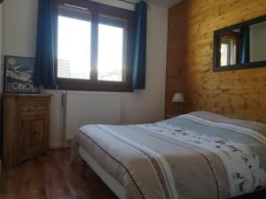 um quarto com uma cama grande e uma janela em La Souloise em Le Dévoluy