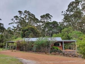a house in the middle of a dirt road at Little River Farm Cottages in Denmark