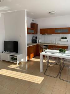 a kitchen with a white table and a television at Apartament Halina in Kołobrzeg