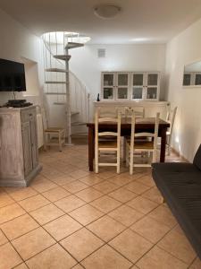 ein Wohnzimmer mit einem Tisch und Stühlen sowie einem TV in der Unterkunft AGORA' Home in Gardone Riviera