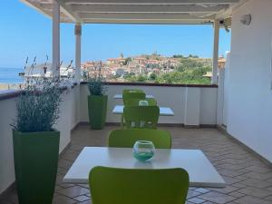 una fila de mesas y sillas en un balcón con vistas al océano en Il Belvedere Guest House, en Scalea