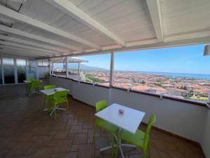 une chambre avec des tables et des chaises et une vue sur la ville dans l'établissement Il Belvedere Guest House, à Scalea