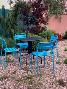 3 Stühle und ein Tisch mit einem blauen Tisch und Stühlen in der Unterkunft Apartmán Papoušek in Znojmo