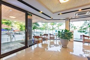 a dining room with a table and chairs and a large window at Moon West Lake Hotel & Residence in Hanoi