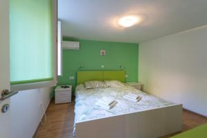 ein Schlafzimmer mit einem Bett und einer grünen Wand in der Unterkunft Apartment Fly in Split