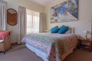 a bedroom with a bed with blue pillows on it at Hamlet Downs Country Accommodation in Fentonbury