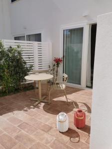 a patio with a table and a chair on a balcony at La Bottarga in Favignana